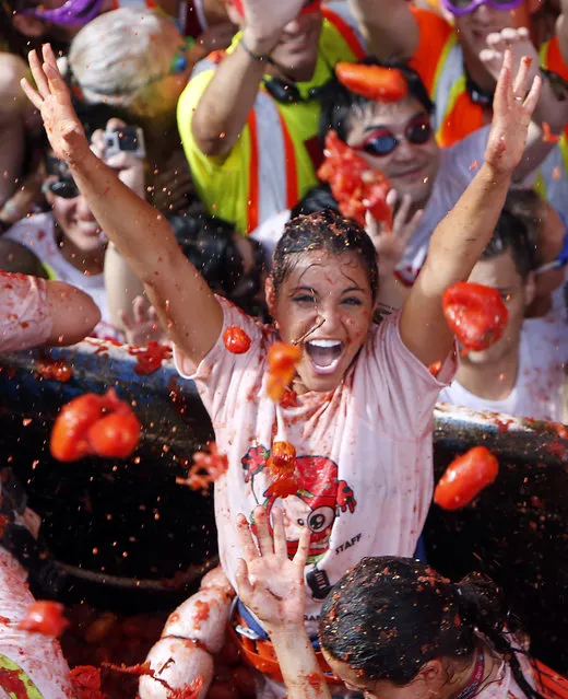 Crowds of people throw tomatoes at each other, during the annual “Tomatina”, tomato fight fiesta, in the village of Bunol, 50 kilometers outside Valencia, Spain, Wednesday, August 31, 2016. (Photo by Alberto Saiz/AP Photo)