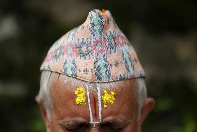 A Nepalese Hindu priest performs rituals during Kuse Aunsi at Gokarneshwar Hindu temple in Kathmandu, Nepal, Thursday, September 1, 2016. Kuse Aunsi is a Hindu festival where fathers, living or dead, are honored. Children with living fathers show their appreciation by giving presents and sweets and those whose fathers are deceased pay tributes at Gokarneshwar temple. (Photo by Niranjan Shrestha/AP Photo)