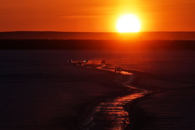 Cars drive along a winter road connecting the banks of the ice-covered Lena River during sunset in Yakutsk on March 29, 2025. (Photo by AFP Photo/Stringer)
