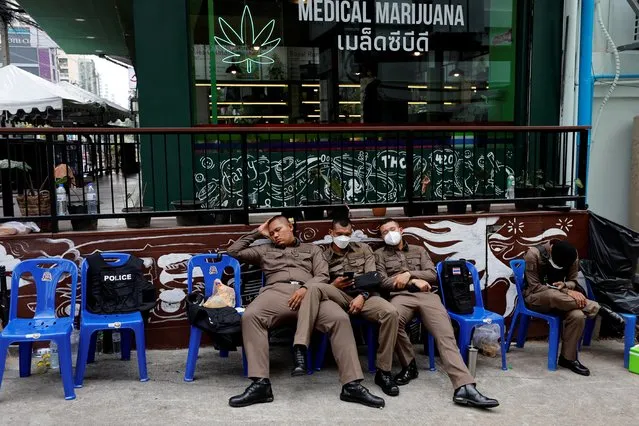 Police officers rest outside a cannabis shop next to the venue of the Asia-Pacific Economic Cooperation (APEC) Summit in Bangkok, Thailand on November 17, 2022. (Photo by Jorge Silva/Reuters)