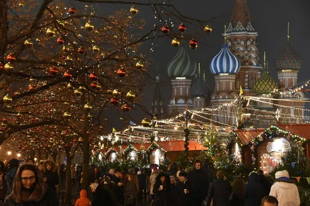 People walk along a Christmas market on the Red Square in Moscow on December 16, 2017. (Photo by Vasily Maximov/AFP Photo)
