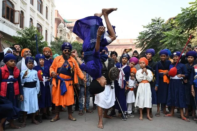 A Sikh youth performs 'Gatka', an ancient form of Sikh martial arts, during a religious procession to mark the martyrdom day of Guru Teg Bahadur at the Golden Temple in Amritsar on November 26, 2022. (Photo by Narinder Nanu/AFP Photo)