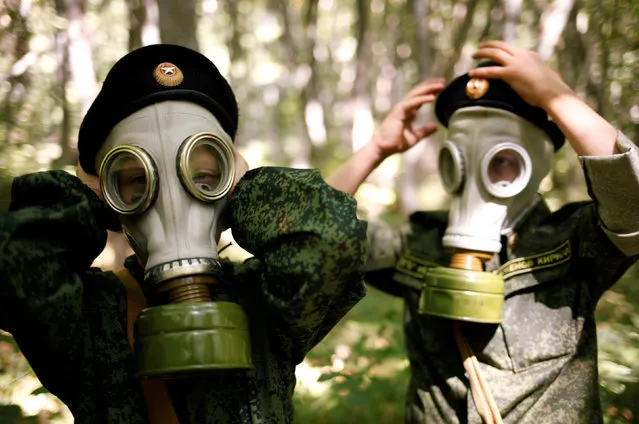 Fifth-grade students of the General Yermolov Cadet School, instructed by a tenth-grader, take on gas masks during their first military tactical exercise on the ground, which includes radiation resistance classes, forest survival studies and other activities, in Stavropol, Russia, September 10, 2016. Picture taken September 10, 2016. (Photo by Eduard Korniyenko/Reuters)