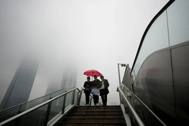 People wearing masks walk on an overpass at Lujiazui financial district, as coronavirus disease (COVID-19) outbreaks continue in Shanghai, China on December 9, 2022. (Photo by Aly Song/Reuters)