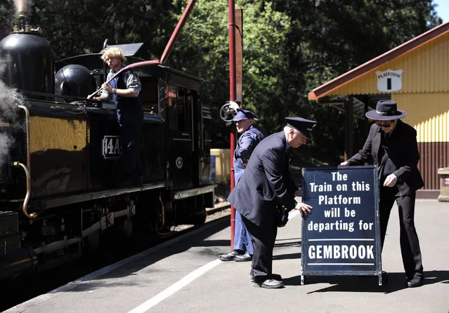 Staff at the Puffing Billy railway station of Lakeside put out a sign for the next arriving train as locomotive 14A is watered on the platform near Melbourne, October 20, 2014. (Photo by Jason Reed/Reuters)