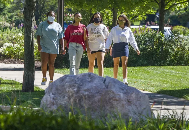 Students wearing masks walk on campus of the University of Notre Dame on Tuesday, August 18, 2020, in South Bend, Ind. (Photo by Robert Franklin/South Bend Tribune via AP Photo)
