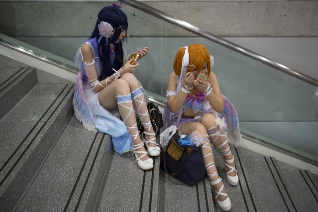 Summer Zhai and Vicky He, dressed as characters from the anime "Love Live!", rest on stairs during day two of New York Comic Con in Manhattan, New York, October 9, 2015. (Photo by Andrew Kelly/Reuters)