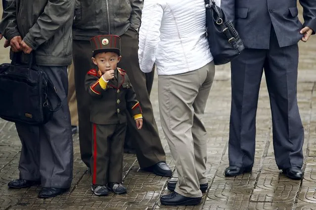 A boy dressed as solider wait for the bus with others in central Pyongyang, October 11, 2015. (Photo by Damir Sagolj/Reuters)