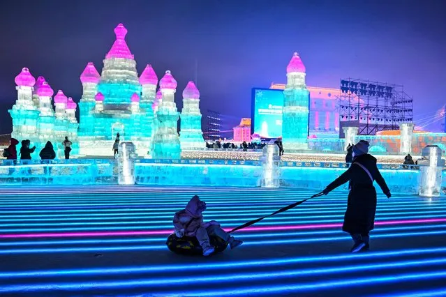 Children play at the Harbin Ice and Snow World in Harbin, in China's northeastern Heilongjiang province on January 5, 2023, during the opening ceremony of the 39th Harbin China International Ice and Snow Festival. (Photo by Hector Retamal/AFP Photo)