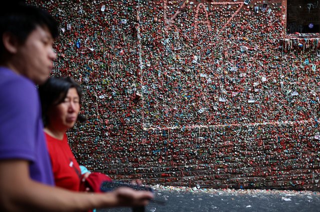 People walk past a wall known as the Gum Wall in Post Alley at Pike Place Market in Seattle, Washington, U.S. June 24, 2025. (Photo by Agustin Marcarian/Reuters)