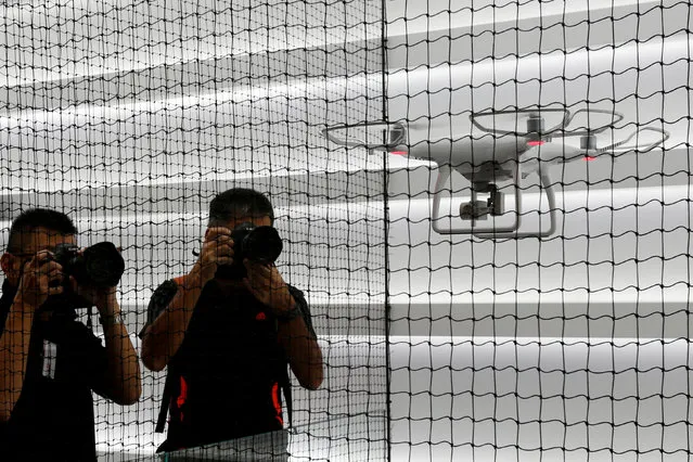 Photographers take photos of a drone flying at DJI's flagship store in Hong Kong, China September 22, 2016, two days before its opening. (Photo by Bobby Yip/Reuters)