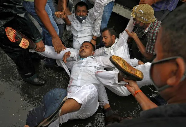 Supporters of India's main opposition Congress party react as they are detained by police during a protest against new farm laws, in Kolkata, India, September 28, 2020. (Photo by Rupak De Chowdhuri/Reuters)