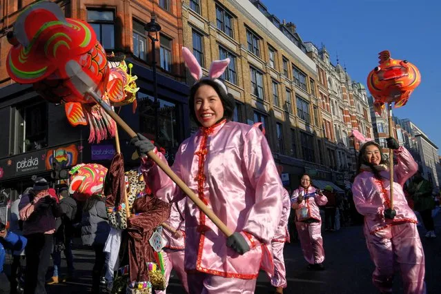 People march through a street during celebrations on the first day of the Lunar New Year in London, Britain on January 22, 2023. (Photo by Toby Melville/Reuters)