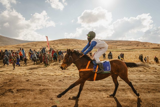 Attendees watch as a jockey crosses the finish line during the annual horse racing event taking place on the first Saturday after King Letsie III's birthday in Semonkong, Lesotho, on July 19, 2025. (Photo by Fredrik Lerneryd/AFP Photo)