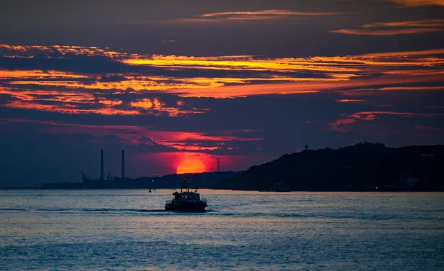 The sunset is pictured over the river Elbe in Hamburg, northern Germany, on August 28, 2017. (Photo by Axel Heimken/AFP Photo/DPA)