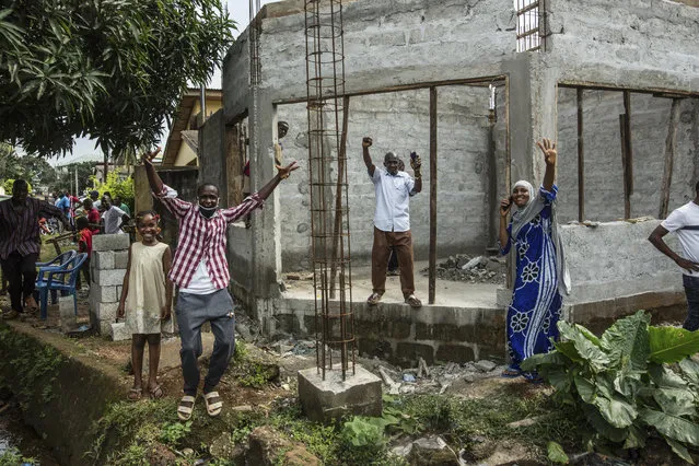 Supporters of Guinean opposition leader Cellou Dalein Diallo cheer at his headquarters in Conakry, Guinea, Monday October 19, 2020. Diallo declared himself the winner after the country held an election on Sunday with Guinean President Alpha Conde seeking to extend his decade in power. (Photo by Sadak Souici/AP Photo)