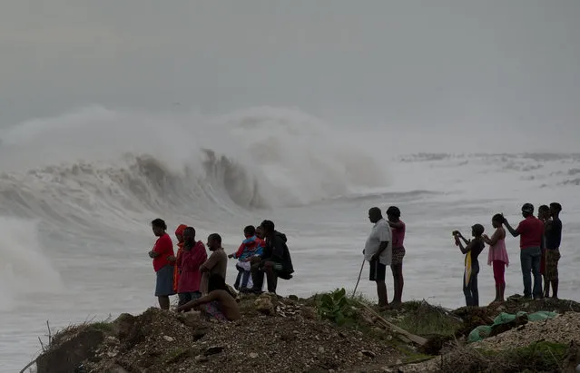 People stand on the coast watching the surf produced by Hurricane Matthew, on the outskirts of Kingston, Jamaica, Monday, October 3, 2016. A hurricane warning is in effect for Jamaica, Haiti, and the Cuban provinces of Guantanamo, Santiago de Cuba, Holguin, Granma and Las Tunas – as well as the southeastern Bahamas. (Photo by Eduardo Verdugo/AP Photo)