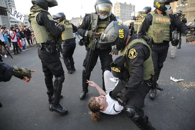 Police detain a protester who was helping to block the road in front of the Justice Palace where people who are refusing to recognize the new government marched to protest, in Lima, Peru, Wednesday, November 11, 2020. On Tuesday, Peru swore in Manuel Merino as president, after Peru’s legislature booted President Martin Vizcarra from office on Monday. (Photo by Rodrigo Abd/AP Photo)