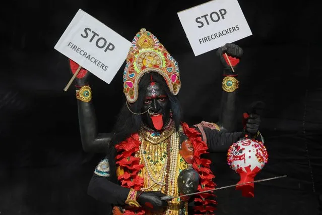 Artisan dressed as Hindu goddess Kali poses for the camera as he takes part in an awareness campaign on the harmful effects of bursting fire crackers after the statewide ban ahead of the Kali Puja festival, in Kolkata, India, November 12, 2020. (Photo by Rupak De Chowdhuri/Reuters)