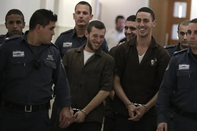 Three Israeli suspects, members of the right-wing Lehava organisation,  are escorted by security to a hearing at the District Court in Jerusalem on December 15, 2014. The three are suspects behind an arson attack  last month that targeted a Jewish-Arab school in Jerusalem on November 29,  badly damaging a classroom and slogans in Hebrew, including “Death to Arabs”, were written on the walls. (Photo by Ahmad Gharabli/AFP Photo)