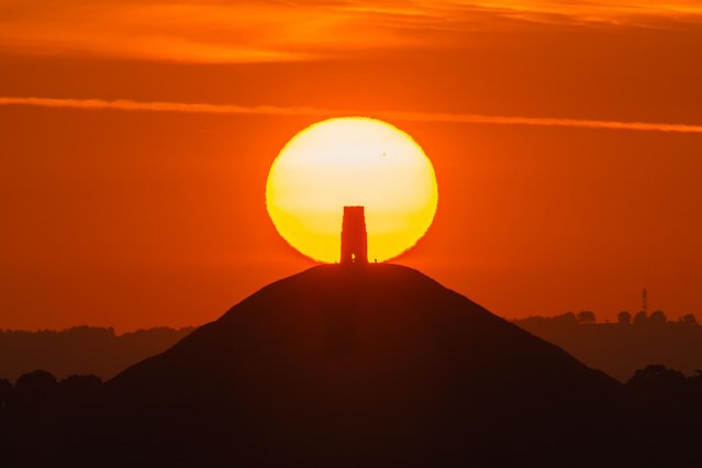 A spectacular sunrise as the sun rises up from behind St Michael's Tower on Glastonbury Tor in Somerset, UK on June 20, 2025 on a hot summer morning during the heatwave. (Photo by Graham Hunt/Alamy Live News)