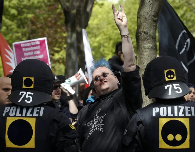 German riot police officers watch the crowd as a protester gestures during a May Day demonstration in Berlin.   (Tobias Schwarz/Reuters)