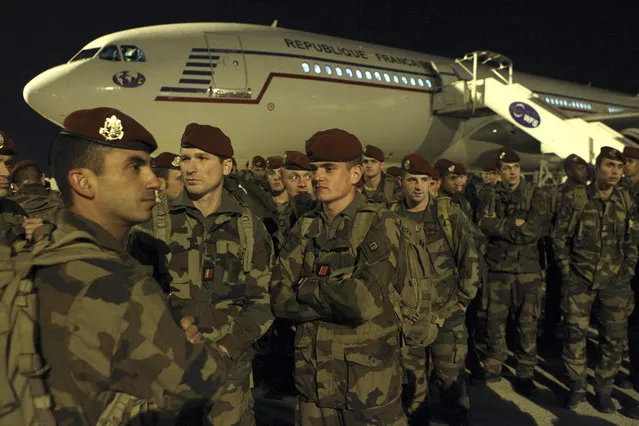 Soldiers stand on the tarmac of the Charles de Gaulle airport, north of Paris, as part of a security reinforcements, Saturday, November 14, 2015. French President Francois Hollande said France would wage “merciless” war on the Islamic State group Saturday, after the jihadists claimed responsibility for a gun and bomb rampage targeting the vibrant cafes, bars and clubs of Paris - an attack on the heart of the City of Light that killed more than 120. (Photo by Michel Spingler/AP Photo)