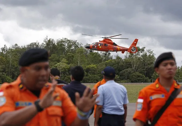 An Indonesian Search and Rescue helicopter carrying the bodies of two AirAsia passengers recovered from the sea prepares to land at the airport in Pangkalan Bun, Central Kalimantan, December 31, 2014. (Photo by Darren Whiteside/Reuters)
