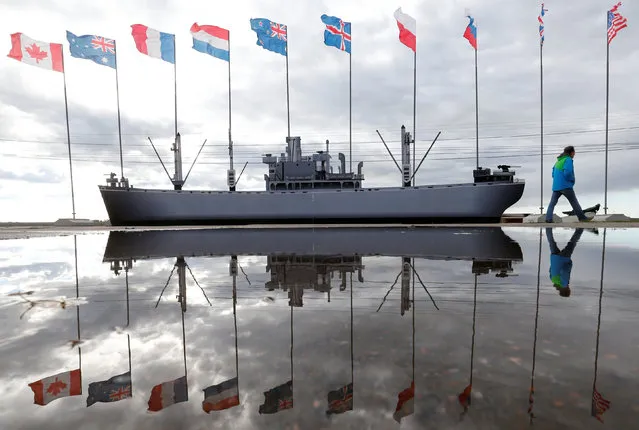 A man walks past flags and a vessel model during the preparation for festive ceremonies commemorating the 75th anniversary of the arrival of the first allied Arctic Convoy, codenamed Operation Dervish, at the northern port of the Soviet Union during World War Two in Arkhangelsk, Russia, August 29, 2016. (Photo by Maxim Zmeyev/Reuters)