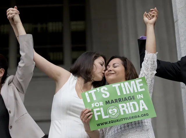 Catherina Pareto, left, and her partner Karla Arguello celebrate on the court house steps after Circuit Court Judge Sarah Zabel lifted a stay on her July ruling that Florida's same s*x marriage ban violates equal protections under the U.S. Constitution, Monday, January 5, 2015 in Miami. (Photo by Wilfredo Lee/AP Photo)