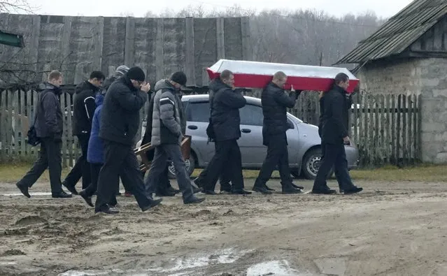 Men carry a coffin during the funeral of Russian serviceman Fyodor Zhuravlyov near a cemetery in the village of Paltso, Bryansk region, Russia, November 24, 2015. Zhuravlyov left home in a rush. He only managed to scrawl a phone number and a few words to his wife on a sheet of paper. Late last week the military contacted the family to say that he was killed in combat on Thursday, Nov. 19. (Photo by Maria Tsvetkova/Reuters)
