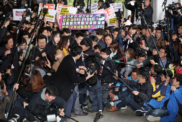 Choi Soon- Sil (C) is surrounded by the media as she arrives at the Seoul Central District Prosecutor' s Office in Seoul on October 31, 2016 South Korean prosecutors questioned the woman at the centre of a political scandal that has shattered public confidence in President Park Geun- Hye, with allegations of fraud and meddling in state affairs. (Photo by AFP Photo/Yonhap)