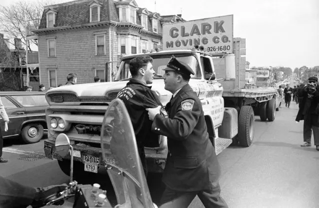 A Boston policeman seizes unidentified youth who sought to interfere with march by group of clergymen and pacifists in South Boston, April 6, 1966. The march was called to assert right to dissent “as the cornerstone of American democracy” in statement signed by 19 clergymen organizers. Group also protested lack of police protection when draft card burners were beaten by youths on steps of South Boston courthouse last week. One hundred fifty police guarded marchers. Youth wears jacket sometimes worn by veterans. (Photo by J. Walter Green/AP Photo)