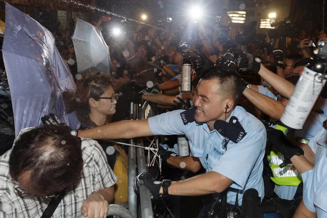 Police clash with protestors at a police barricade outside the Chinese government's headquarters in Hong Kong, China, 06 November 2016. Thousands of protestors marched through the streets of Hong Kong to protest against the Chinese government's controversial decision to decide the fate of two Hong Kong lawmakers who refused to pledge allegiance to the Hong Kong constitution and swore featly to the Hong Kong nation instead. (Photo by Alex Hofford/EPA)