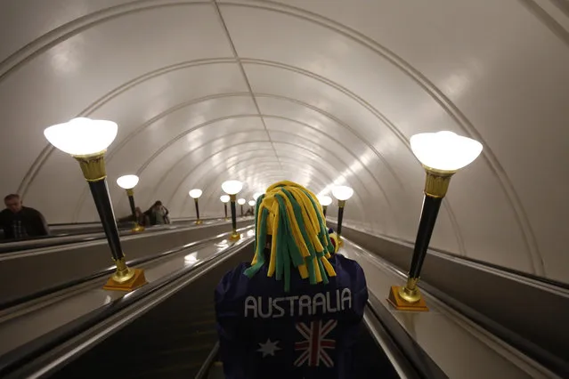 A Colombian man who lives in Australia wears a flag supporting the Australian team as he descends into a subway in Moscow, Russia, during the 2018 soccer World Cup, Friday, June 15, 2018. (Photo by Rebecca Blackwell/AP Photo)