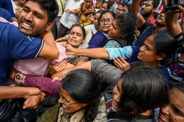 Activists of Socialist Unity Centre of India (SUCI) scuffle with police as they demonstrate to support the Indian wrestlers' atrocities whilst they protest against Brij Bhushan Singh, the wrestling federation chief over allegations of sexual harassment and intimidation, in Kolkata on May 29, 2023. (Photo by Dibyangshu Sarkar/AFP Photo)