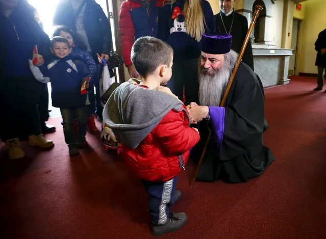 Bishop Meghrig Parikian greets Syrian refugees at a welcome service at the St. Mary Armenian Apostolic Church at the Armenian Community Centre of Toronto in Toronto, December 11, 2015. (Photo by Mark Blinch/Reuters)