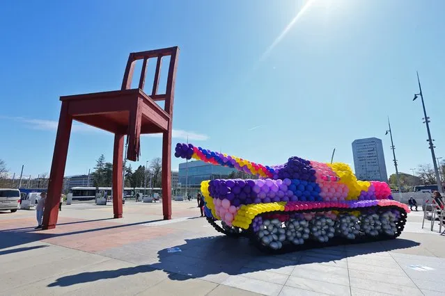 A life-size tank, entirely made with inflatable balloons of biodegradable latex, is pictured during the launch of the “Stop Bombing Civilians” campaign by Handicap International in front of the United Nations and next to the “Broken Chair” sculpture, in Geneva, Switzerland on April 5, 2022. (Photo by Denis Balibouse/Reuters)
