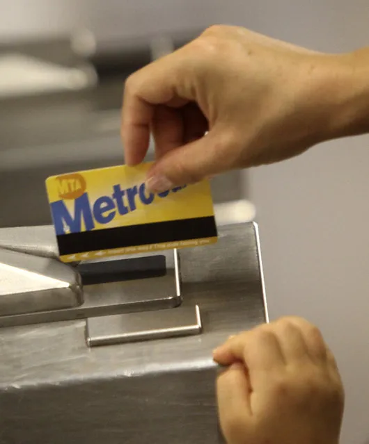 A subway rider swipes a MetroCard through the turnstiles in New York, July 28, 2010. New York's transit agency is proposing fare increases of more than 16 percent for monthly subway and bus passes and 9 percent hikes on suburban trains, another blow to commuters still getting used to service cuts last month that eliminated some subway and bus routes. (Photo by Seth Wenig/AP Photo)