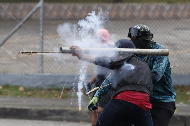 Demonstrators clash with members of Panama's Riot Control Unit (UCM) during the national strike in Panama City, Panama, 21 March 2025. Teachers' unions went on strike , partially paralyzing public schools, leaving minor clashes with the police and blocking some roads, to protest against the social security reform approved this week. (Photo by Bienvenido Velasco/EPA)