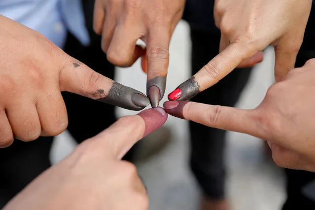 Cambodian voters take pictures of their ink stained fingers after they voted, outside a polling station during a general election in Phnom Penh, Cambodia July 29, 2018. (Photo by Darren Whiteside/Reuters)