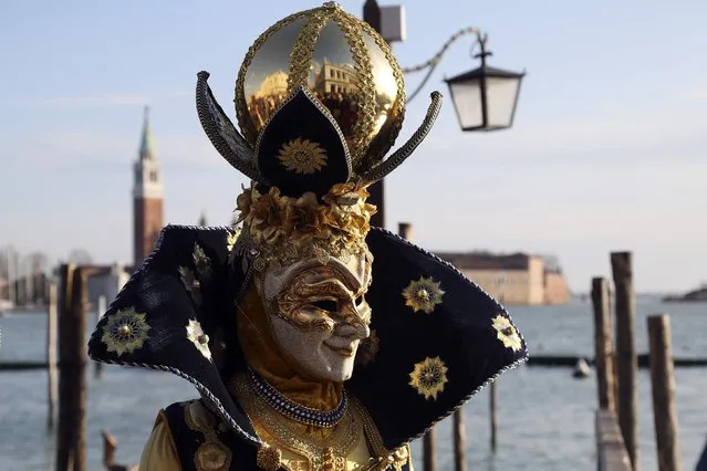 A masked reveller poses in front of St. Mark's Square during the Venice Carnival, February 7, 2015. (Photo by Stefano Rellandini/Reuters)