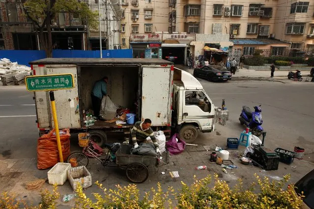 Men load recyclables into a van at a pop-up collection point in a residential area in Beijing, China, November 3, 2016. As authorities try to control Beijing's burgeoning population and capitalize on skyrocketing land prices, scrap collectors say they are being pushed out despite playing a vital role in China's unique recycling ecosystem. Working in the shadow of Beijing's looming skyscrapers, Yin Xueqiang weighs a pile of cardboard and old shoe rack in a dusty scrap yard, the latest casualty of a crackdown on migrant workers in China's capital. Last week, security guards blocked the road used by Yin and his fellow scrap collectorsto enter the yard. Signs posted by local authorities earlier this month had given the collectors 10 days to leave. (Photo by Thomas Peter/Reuters)