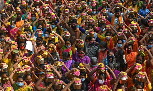 Hindu devotees carry urns containing milk on their head while taking part in a religious procession to celebrate the Panguni Uthiram festival in Chennai on March 28, 2021. (Photo by Arun Sankar/AFP Photo)