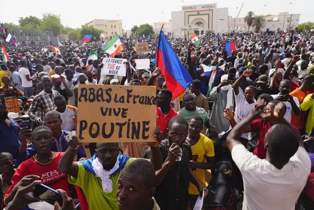 Nigeriens participate in a march called by supporters of coup leader Gen. Abdourahmane Tchiani in Niamey, Niger, Sunday, July 30, 2023. Days after mutinous soldiers ousted Niger's democratically elected president, uncertainty is mounting about the country's future and some are calling out the junta's reasons for seizing control. The sign reads: “Down with France, long live Putin”. (Photo by Sam Mednick/AP Photo)