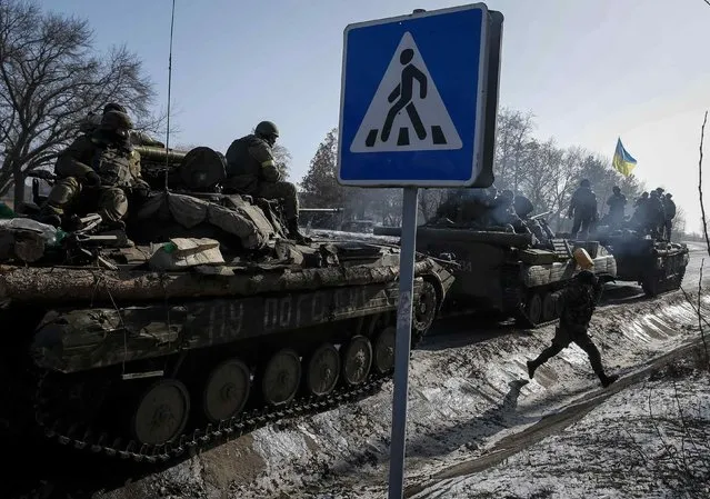 Members of the Ukrainian armed forces ride on armoured personnel carriers (APC) near Debaltseve, eastern Ukraine, February 12, 2015. (Photo by Gleb Garanich/Reuters)