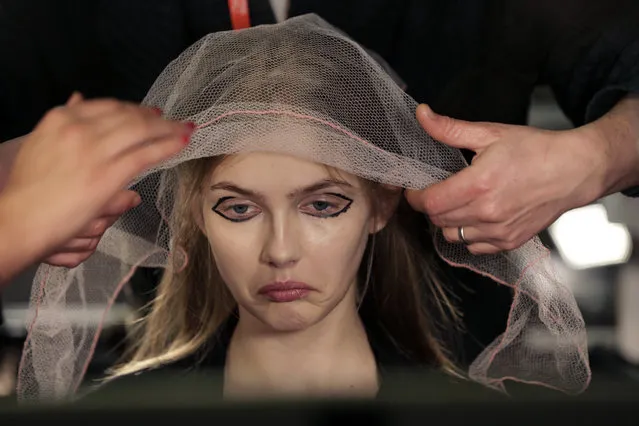 A model has her hair styled backstage before the DKNY Fall 2015 collection is modeled, during Fashion Week, in New York, Sunday, February 15, 2015. (Photo by Richard Drew/AP Photo)