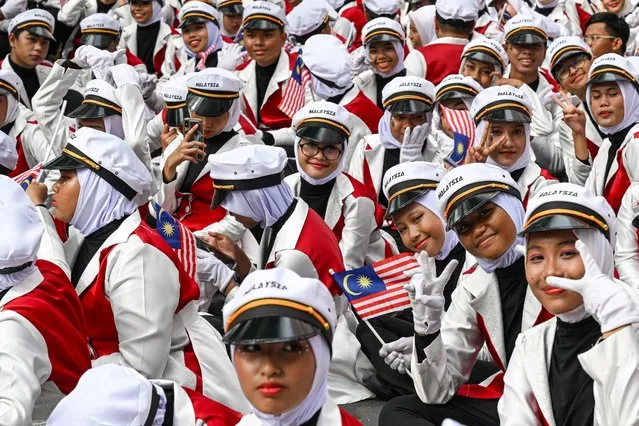 Volunteers wait before taking part in the 66th National Day celebrations in Malaysia's administrative capital Putrajaya, on August 31, 2023. The country commemorates the independence of the Federation of Malaya from British rule in 1957. (Photo by Mohd Rasfan/AFP Photo)