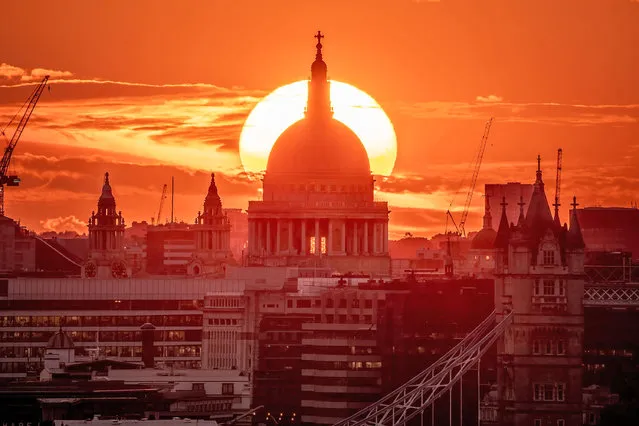 A dramatic evening sun aligns itself behind St. Paul's Cathedral in London ending a warm Tuesday on July 25, 2023. (Photo by Guy Corbishley/Alamy Live News)