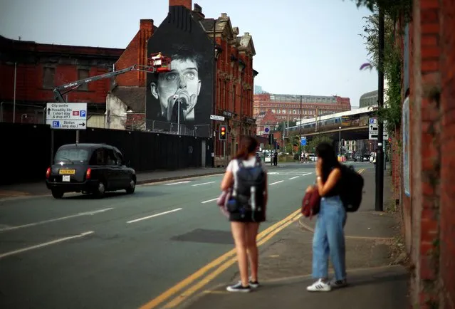 Artist Akse P19 works on a mural of singer Ian Curtis of Joy Division in Manchester, Britain on September 8, 2023. (Photo by Phil Noble/Reuters)
